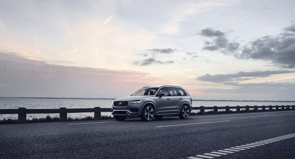 Volvo XC90 fährt über eine Straße im Hintergrund Wasser
